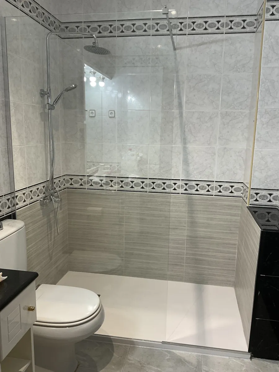 Ducha con mampara y banda de mosaico